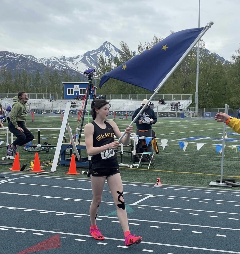 ourea waving Alaska flag after state track and field meet