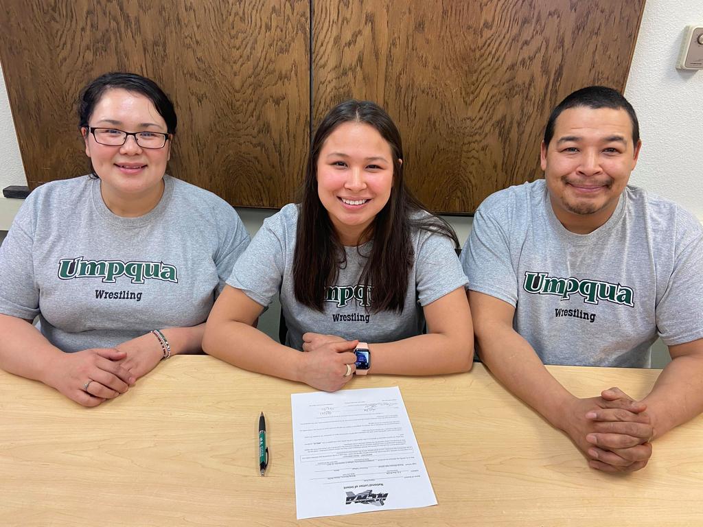 Alaina Pete of Brevig Mission sitting with her parents after signing her letter of intent to wrestle at Umpqua Community College.