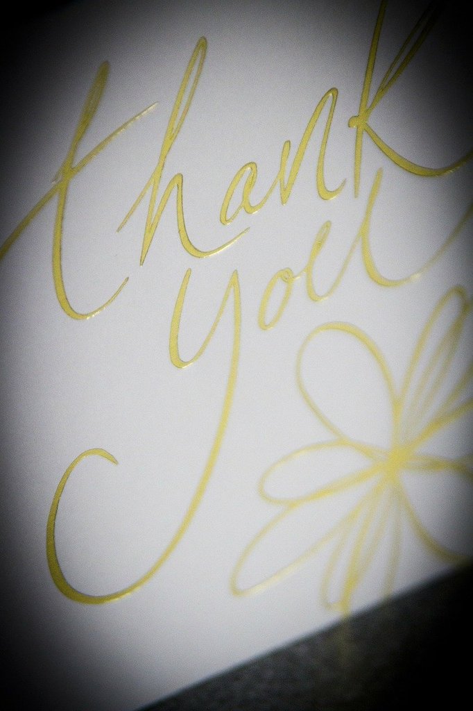 A thank you card with gold lettering.