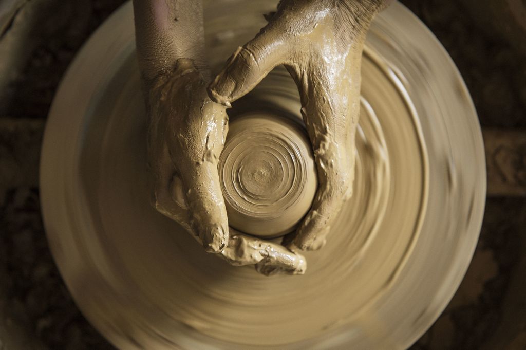 Hands and clay turing on a pottery wheel.
