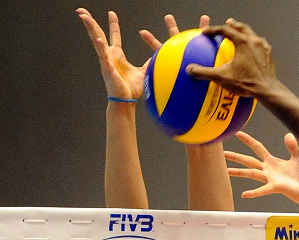A volleyball and hands